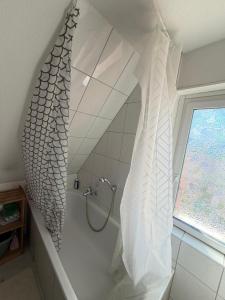 a bathroom with a shower with a fish shower curtain at Room in Rendsburg in Rendsburg +5 photos