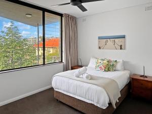 a bedroom with a bed and a large window at BRON455B - Bronte Beach House with Ocean Views in Sydney