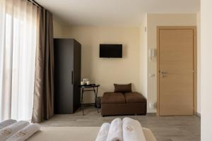 a hotel room with a couch and a television at La Dimora Aragonese in Randazzo