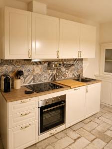 a kitchen with white cabinets and a stove top oven at Casa Il Borgo in Tavernelle