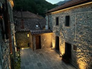 an outdoor courtyard of a stone building with lights at Casa Il Borgo in Tavernelle