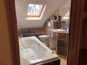 a bathroom with a tub and a toilet and a sink at La Tour Des Lys in Maubeuge