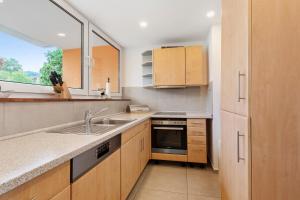 a kitchen with wooden cabinets and a sink and a window at Apartment Melody in Oberkochen +19 photos