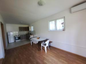 a kitchen and dining room with a table and chairs at Family Nature Escape in Malešići