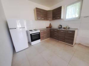 a kitchen with a white refrigerator and brown cabinets at Family Nature Escape in Malešići +4 photos