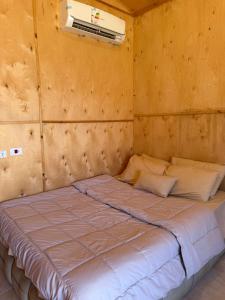 a large bed in a room with a wall at Moon Dune Camp in Nuweiba