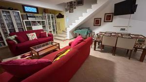 a living room with two red couches and a table at Villa Shiva Cerveteri, Casa Vacanze con SPA e Idromassaggio, Relax a due passi da Roma in Cerveteri