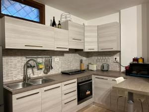 a kitchen with wooden cabinets and a sink at Villa Shiva Cerveteri, Casa Vacanze con SPA e Idromassaggio, Relax a due passi da Roma in Cerveteri