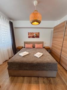 a bedroom with a bed with two towels on it at Central-home in Târgu Jiu