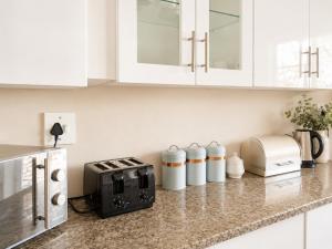 a kitchen with white cabinets and a counter with a toaster at Azania Bed & Breakfast in Meyerton