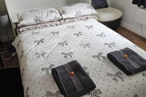a bed with two bags sitting on top of it at Newly Renovated Studio in Bishop's Stortford in Bishops Stortford