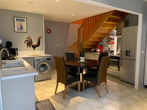a kitchen and dining room with a table and a chicken on the wall at La Maison Clémenso in Cluny