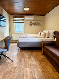 a bedroom with a large bed and a couch at RESTAURACE A PENZION U DOUBKŮ in Břeclav +26 photos
