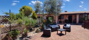a patio with furniture and plants in front of a house at Villa Shiva Cerveteri, Casa Vacanze con SPA e Idromassaggio, Relax a due passi da Roma in Cerveteri