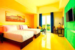 a hotel room with two beds and a television at Hotel Radhakunj Inn in Dhanbād