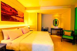 a bedroom with a large bed and a desk at Hotel Radhakunj Inn in Dhanbād