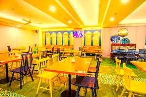 a restaurant with wooden tables and chairs in a room at Hotel Radhakunj Inn in Dhanbād