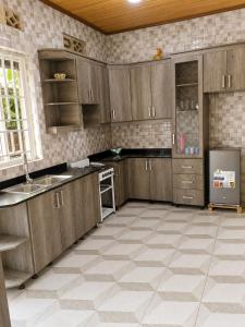 a kitchen with wooden cabinets and a tile floor at The Gathering in Kigali