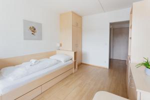 a bedroom with a large bed with white sheets at myNext - Riverside Hotel Salzburg in Salzburg
