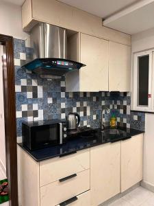 a kitchen with a microwave and a black counter top at Sky residences in Lahore +27 photos