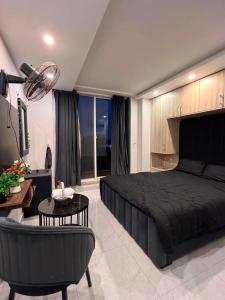 a bedroom with a black bed and a living room at Sky residences in Lahore