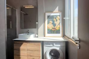 a bathroom with a washing machine and a sink at Lisbon, beach, city & surf in Trafaria +43 photos