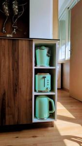 a cupboard with pots and pans in a kitchen at Lisbon, beach, city & surf in Trafaria