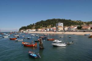 a group of boats in the water near a beach at Lisbon, beach, city & surf in Trafaria
