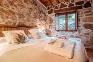 a bedroom with a large bed in a stone wall at El Pajar de Tío Mariano in Tremedal