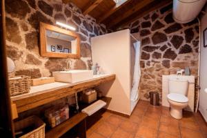 a stone bathroom with a sink and a toilet at El Pajar de Tío Mariano in Tremedal +22 photos