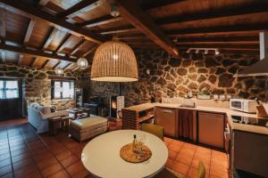 a kitchen and living room with a table in a room at El Pajar de Tío Mariano in Tremedal