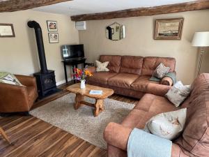 a living room with a couch and a wood stove at The Piggery Dulverton in Dulverton