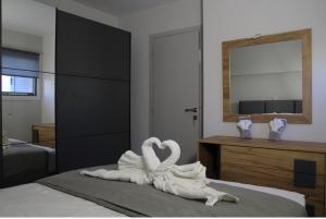 two swans made out of towels sitting on a bed at Thaleia apartment in Igoumenitsa