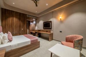 a hotel room with a bed and a tv at Hotel Highway King Dhodsar in Gūdha