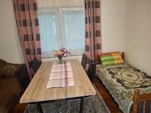 a dining room with a wooden table and a couch at Jasmir in Bihać +6 photos