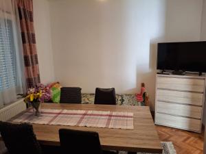 a living room with a table and a tv at Jasmir in Bihać