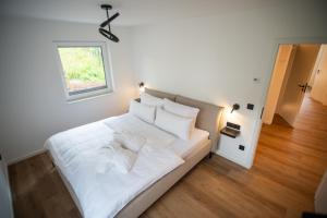 a white bed in a room with a window at Eickhagen Nº7 - 10 Personen - 5 Schlafzimmer - 220qm - 4 Badezimmer - Wellness - Sauna in Olsberg