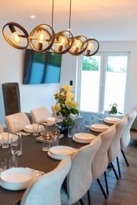 a dining room with a table with chairs and a chandelier at Eickhagen Nº7 - 10 Personen - 5 Schlafzimmer - 220qm - 4 Badezimmer - Wellness - Sauna in Olsberg