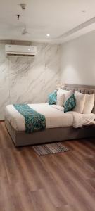 a large bed in a room with wooden floors at MahantaINN in Faizābād