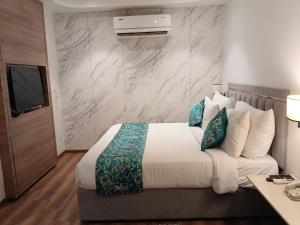 a hotel room with a bed and a television at MahantaINN in Faizābād