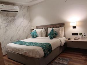 a bedroom with a bed and a desk in it at MahantaINN in Faizābād