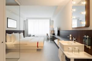 a bedroom with a bed and a sink and a mirror at Ruby Frida Hotel Stockholm by IHG in Stockholm