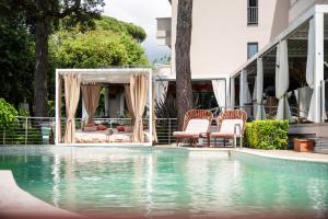a swimming pool with chairs next to a house at Hotel St.Mauritius in Forte dei Marmi