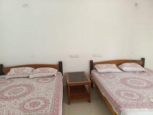 two beds sitting next to each other in a room at Avish Dubbansasi Beach stay Resort Gokarna in Gokarn