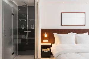 a bedroom with a shower and a bed at Ruby Frida Hotel Stockholm by IHG in Stockholm