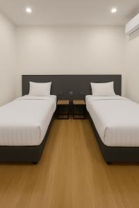 two beds sitting next to each other in a room at Houi Hotel in Jodoh