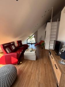 a living room with a red couch and a tv at Ferienwohnung Zwischenhoch in Kranenburg