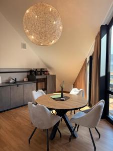 a dining room with a table and chairs and a kitchen at Ferienwohnung Zwischenhoch in Kranenburg