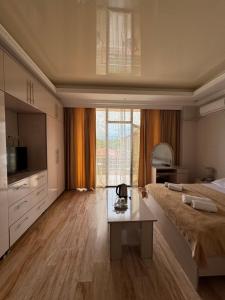 a large bedroom with a large bed and a table at Hotel BellMar in Kobuleti