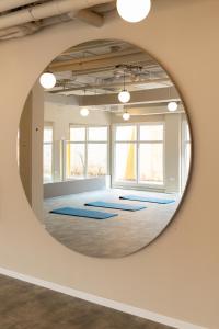 a round mirror reflecting a yoga room with blue mats at Canvas Valencia Burjassot in Burjassot